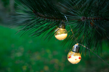 Light bulbs garland on a Christmas tree on a blurred green background
