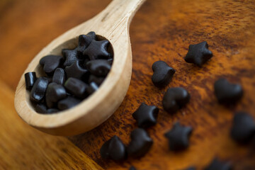 caramelle di liquirizia con cucchiaino di legno su legno