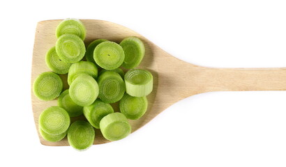 Chopped leek slices pile with wooden spoon isolated on white, top view
