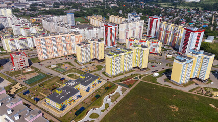 City, locality. Construction site, residential area on a sunny summer day. Apartment buildings, high-rise buildings. The view from the drone, from above.
