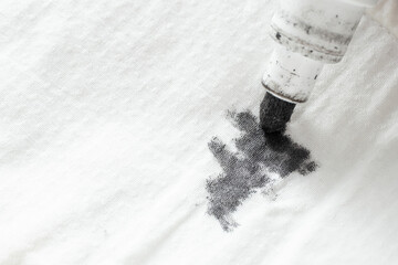 Black ink marker tip, scribbling on white fabric