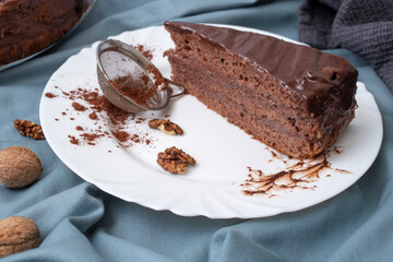 Triangle slice of a chocolate cake, on a white plate,