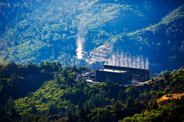 Geothermal electricity power plant in forested, mountainous area