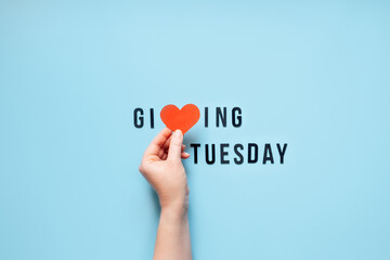 Giving Tuesday, Give, Help, Donation, Support, Volunteer concept with red heart in female hands and text Giving Tuesday on blue background. Its time to give - obrazy, fototapety, plakaty