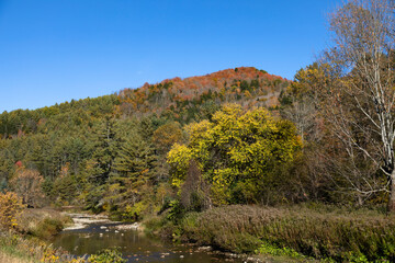 Autumn landscape with river is seen from Route 110, Vermont, USA