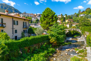 Fototapeta na wymiar A small stream or river runs through the old town center of the lakefront town of Menaggio, Italy, on the shores of Lake Como.