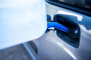 Pouring adblue to the car. Male driver adding Diesel exhaust fluid to his car.