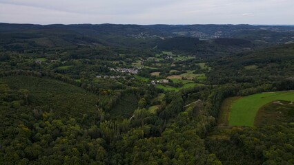 Vallée boisée et bocage sous un ciel gris, vue aérienne © Cyril