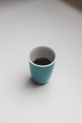 blue cup of brewed coffee on a white table