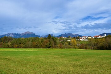Fototapeta na wymiar Scenic view of Karavanke mountains and the town of Radovljica above a green field in Gorenjska, Slovenia