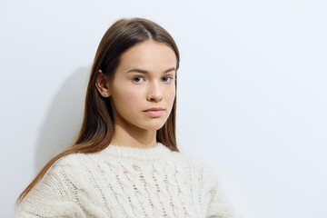 horizontal studio photography on a light background of a beautiful, attractive woman in a stylish sweater looking at the camera