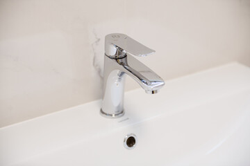 metal water tap on a white sink