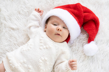 Christmas portrait of cute little newborn baby girl, wearing santa hat and hugging little cute...