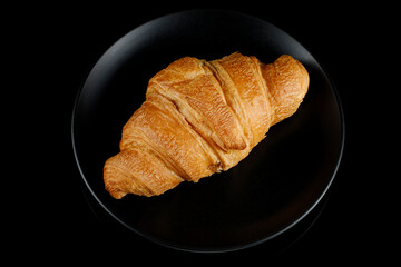 Croissant on a black plate. Top view