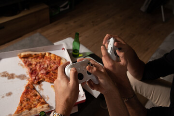 Close up of the hands of two friends playing video games. Gaming concept