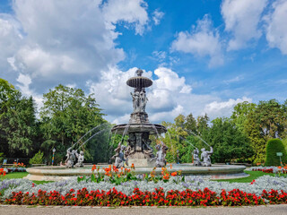 Fototapeta premium Beautiful fountain in the city park Stadtpark, a green island in the middle of the city center of Graz, Styria region, Austria. Selective focus