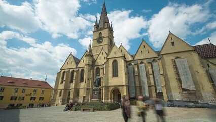 SIBIU, ROMANIA - APRIL 20, 2019: Zoom in Timelapse View of People visiting the Lutheran Cathedral of Saint Mary tower in Sibiu, Romania