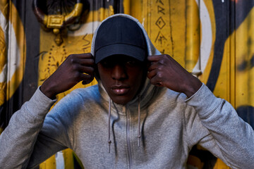 Black man putting on hoodie