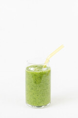 Green smoothie in glass with eco-friendly glass straw. White