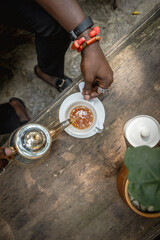 pouring ginger tea into a tea cup