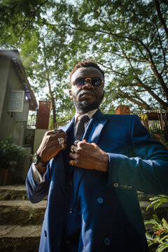 a black man is a short suit posing for portrait in a power pose