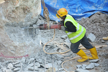 JOHOR, MALAYSIA -JANUARY 13, 2015: A construction workers cutting foundation pile using hacking...