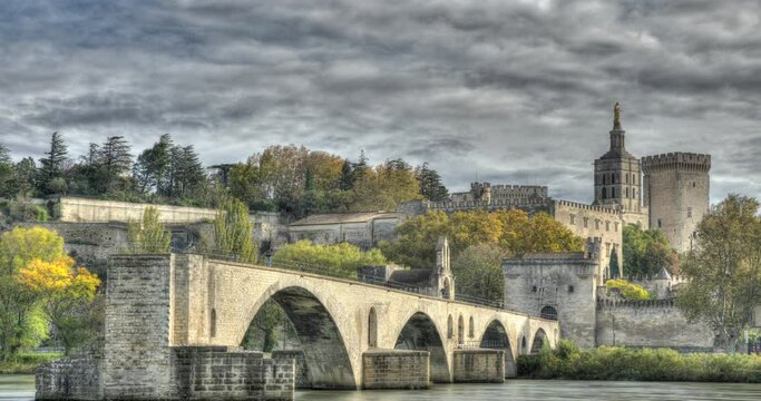 HDR Timelapse of people visiting Pont d'Avignon 12th century bridge and city skyline in Avignon, Provence, France. Zoom effect