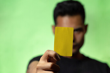 
Hombre mostrando tarjeta roja o amarilla en fondo verde concepto de árbitro futbol o deporte en general. Amonestación deportiva.
 - obrazy, fototapety, plakaty