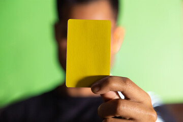 
Hombre mostrando tarjeta roja o amarilla en fondo verde concepto de árbitro futbol o deporte en...