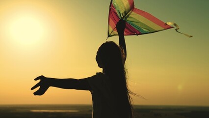 kite. colored rainbow kite hands girl with long hair. happy family. chidhood dream. girl park sunset playing with kite. child teenager journey. fantasy child. concept kite wind. play game nature. - Powered by Adobe