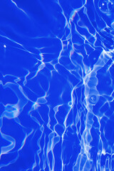 Defocus blurred transparent blue colored clear calm water surface texture with splashes and bubbles. Trendy abstract nature background. Water waves in sunlight with copy space. Blue watercolor shining
