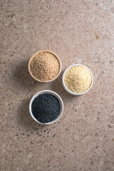 Set with different sesame seeds on stone background. top view.