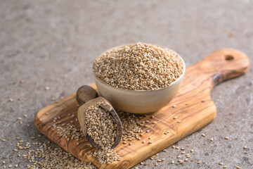Sesame seeds in a little bowl on stone background. top view.