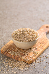 Sesame seeds in a little bowl on stone background. top view.