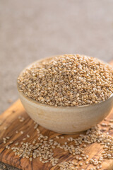 Sesame seeds in a little bowl on stone background. top view.