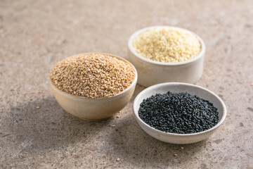 Set with different sesame seeds on stone background. top view.