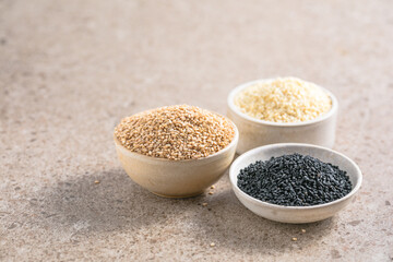 Set with different sesame seeds on stone background. top view.