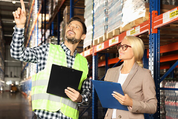 Manager and worker in warehouse with lots of products