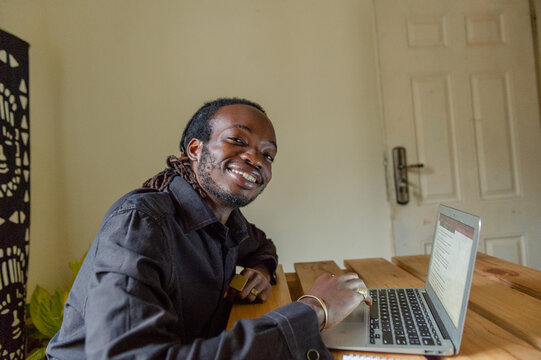 man smiling working on a laptop