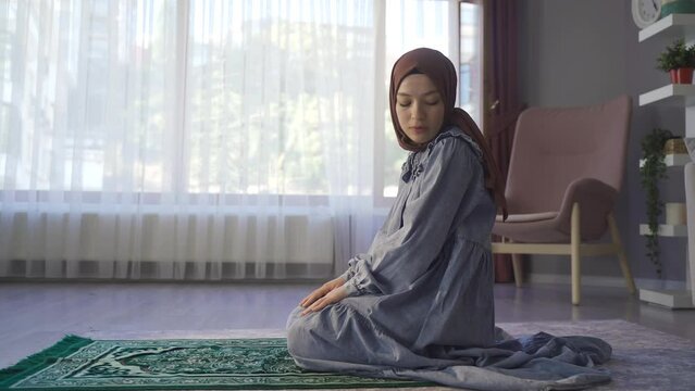 Muslim woman whose religion is islam is praying.
Happy young muslim woman praying in islamic faith.
