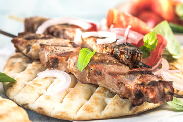 Pork souvlaki, kebabs on skewers with  salad and fresh home made tzatziki