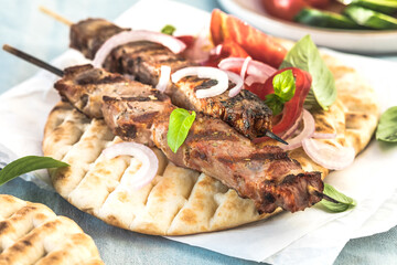 Pork souvlaki, kebabs on skewers with  salad and fresh home made tzatziki