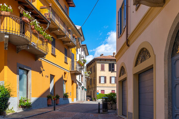 Fototapeta na wymiar A colorful street of shops and cafes in the historic center of the lakefront town of Menaggio, Italy, on the shores of Lake Como.