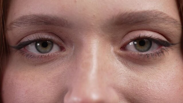 Half face with eyes of pretty ginger woman, natural beauty. Young serious girl with european appearance looking at camera. 