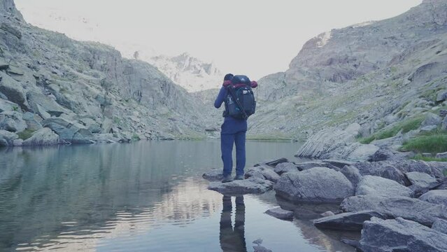 a solo hiker stand alone by the lake, and walk away.