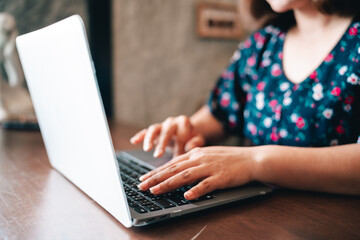 A young woman using a laptop computer. . Woman working on a laptop in the house. online seller