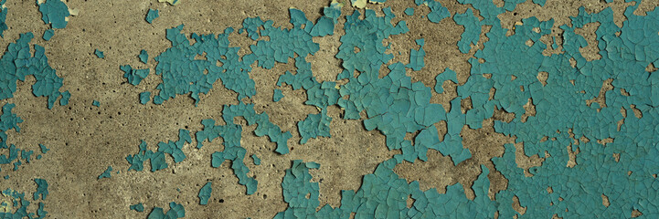 Peeling paint on the wall. Panorama of a concrete wall with old cracked flaking paint. Weathered rough painted surface with patterns of cracks and peeling. Wide panoramic texture for grunge background