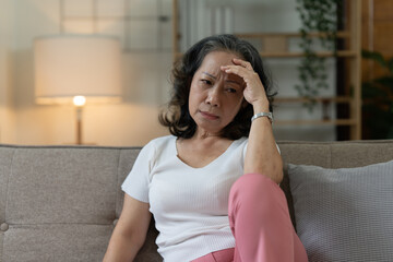 Depressed Elderly Asian woman sitting alone at home. Retired woman concept.