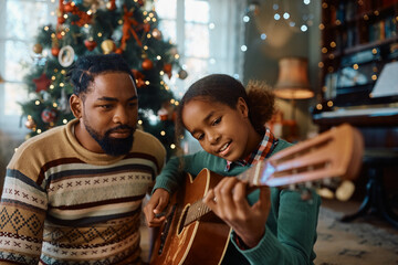 Black girl plays acoustic guitar while spending Christmas with her father at home.