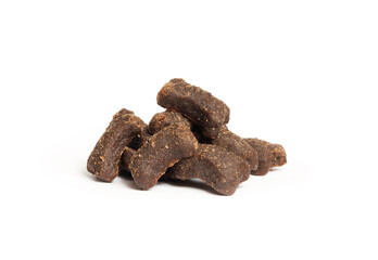 Pile of semi moist kibbles or for dogs or cats. Isolated soft and chewy pet food pieces. Brown soft kibble with lamb as mono protein. Selective focus. White background.
